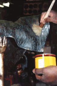 Applying wax to a sculpture to preserve its quality